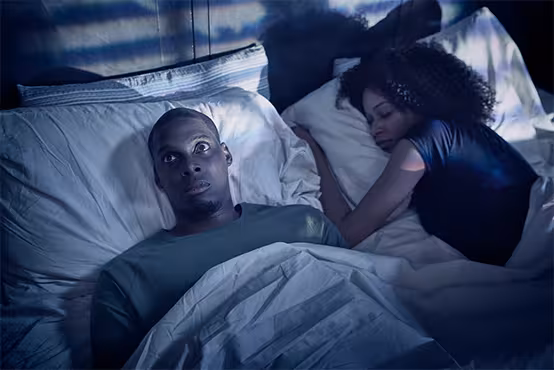 Man wide awake in bed